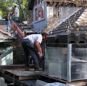 传送带将混凝土瓦屋顶从卡车的车底输送到屋顶。